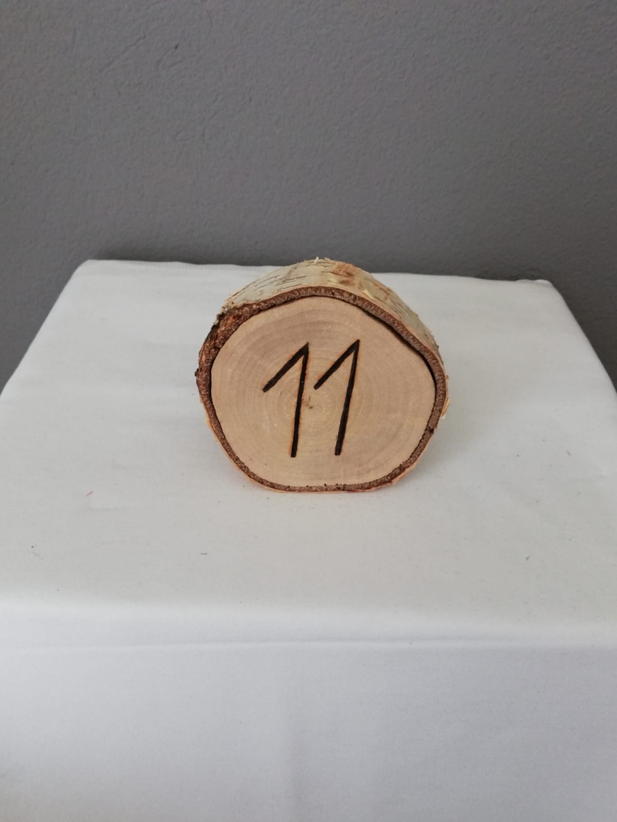 Holzscheibe mit Tischnummer 11 darauf für Hochzeiten und Events
